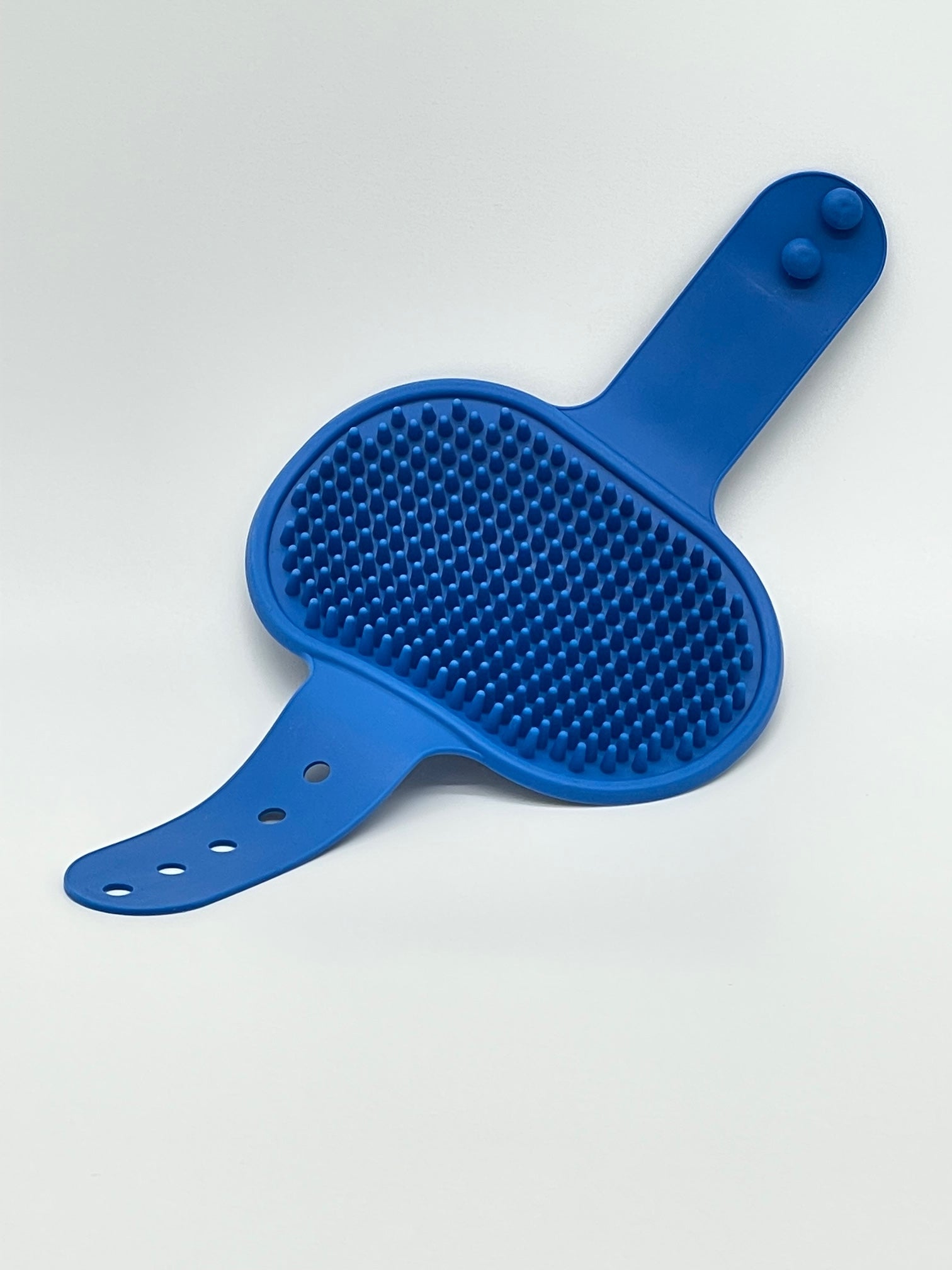 Pet grooming brush from Toys N Treats Box, showing a pet massage and shampoo tool with bristles for gentle grooming.