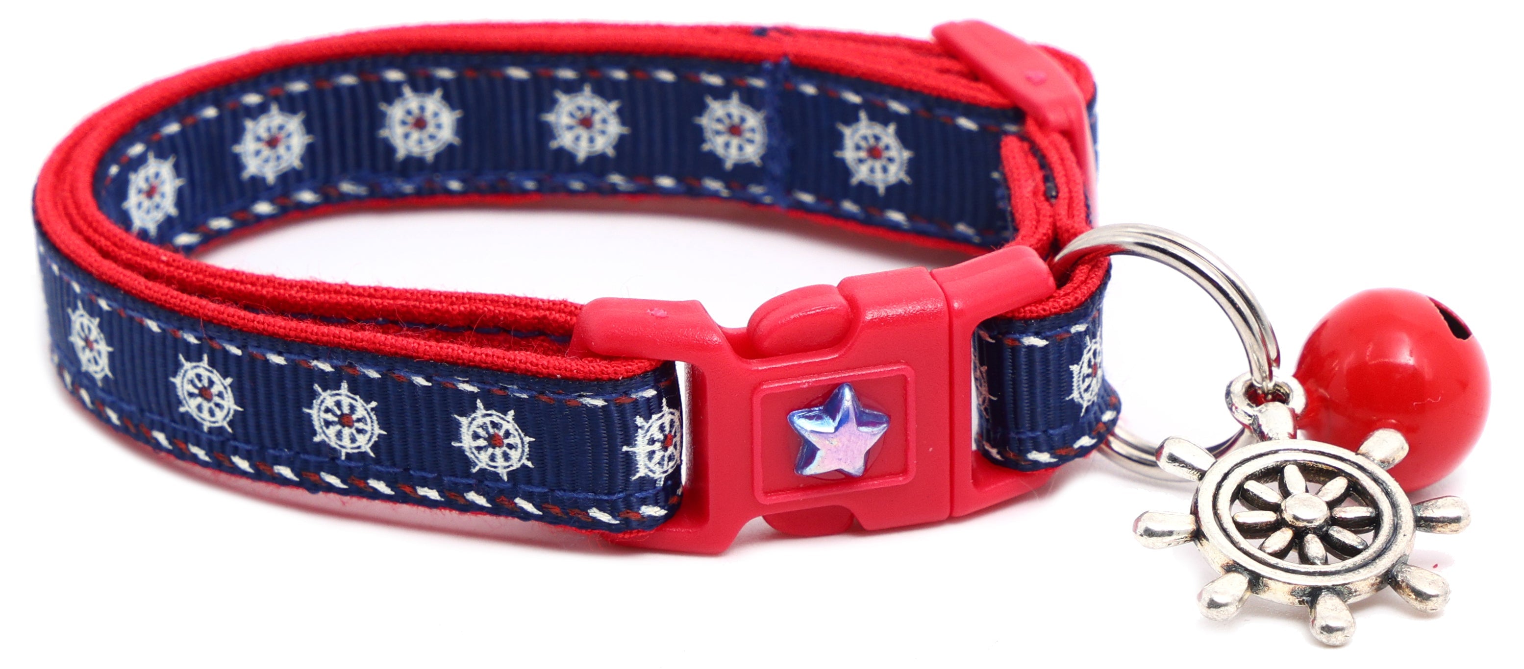 Nautical design Ships Wheels breakaway cat collar by Pugs2Persians on a curious kitten, featuring a small ship wheel charm and adjustable fit.